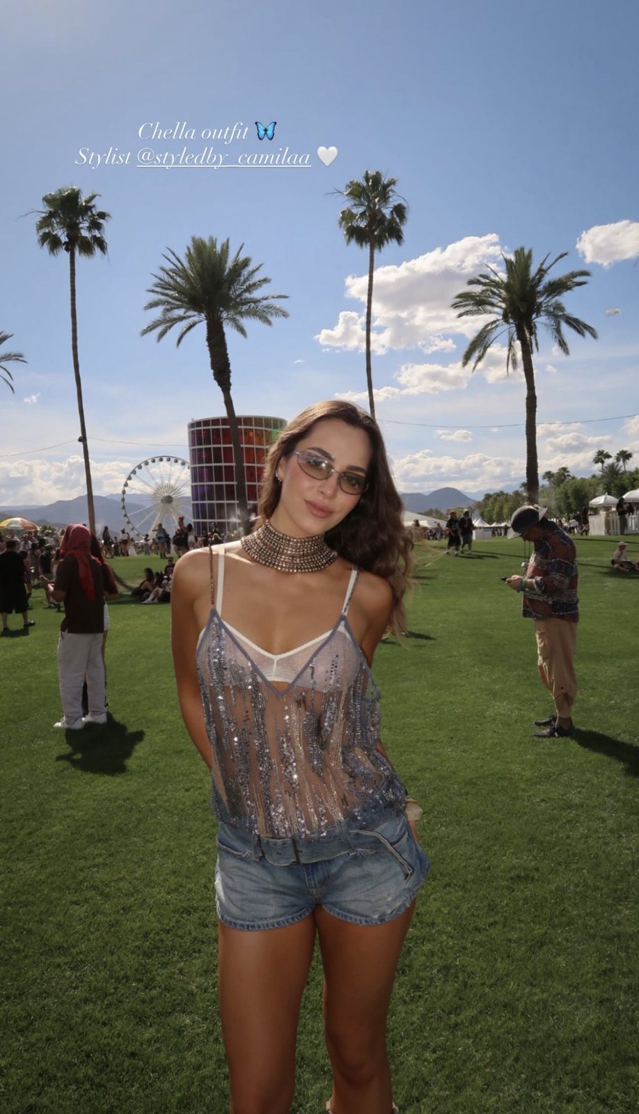 Client at Coachella in a sheer embellished top, denim shorts, and a crystal choker
